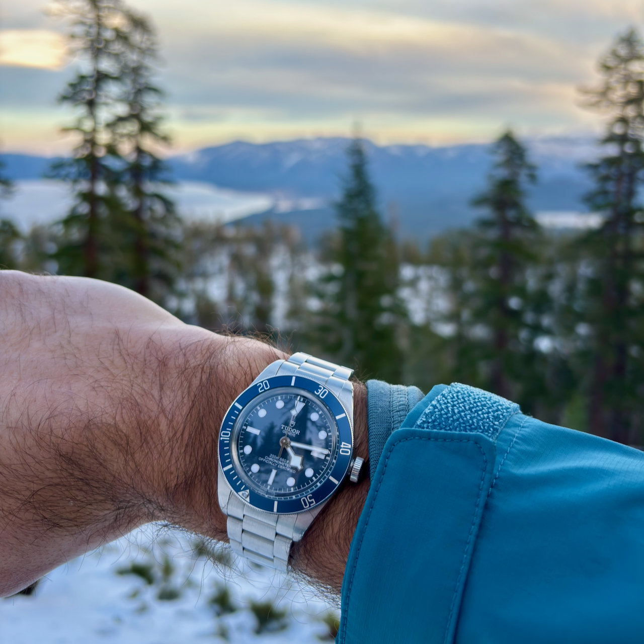 The Black Bay 58 Blue on a hike overlooking Lake Tahoe from a snow-capped mountain.